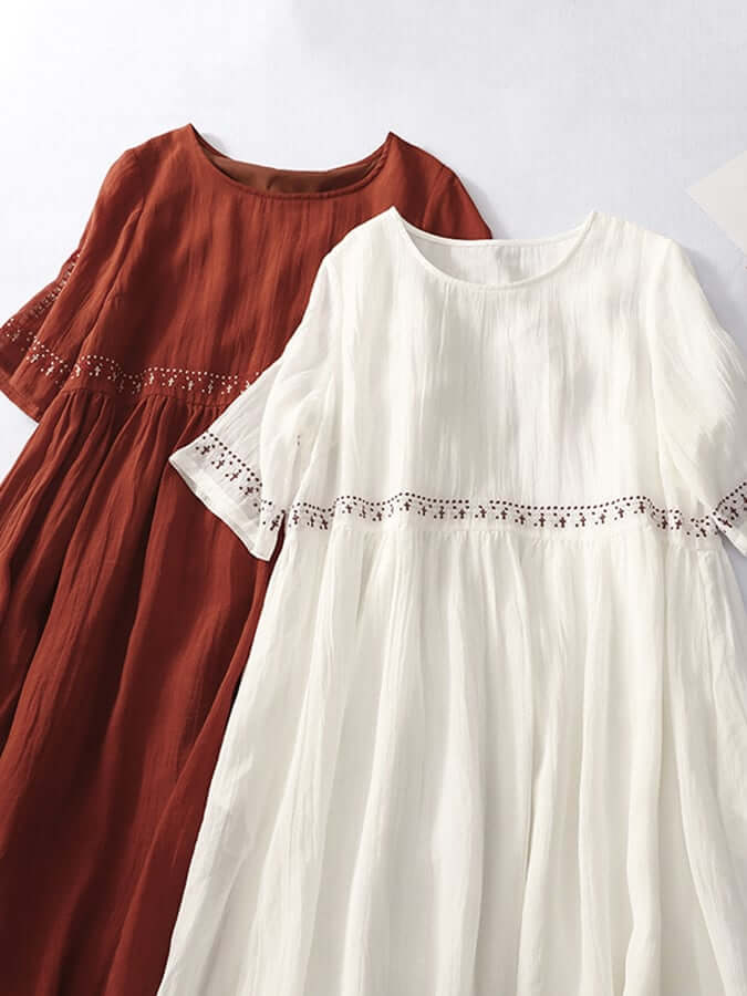 Woman wearing a stylish embroidered loose cotton linen dress, perfect for a relaxed summer day.