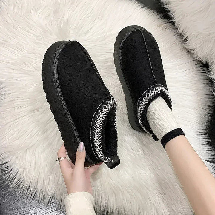 Fashionable women's slip-on mules with a cozy fleece lining, offering casual style and warmth for cold weather.