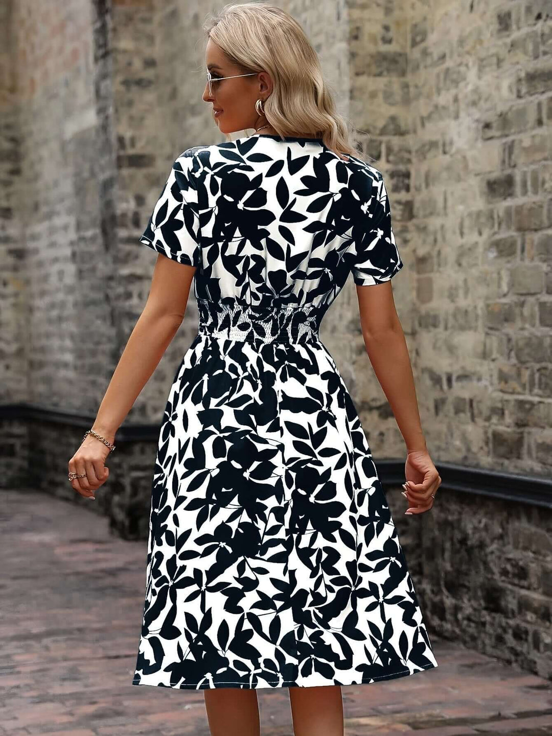 Flowy, comfortable women's floral midi dress in motion, showcasing its elegant smocked design for summer.