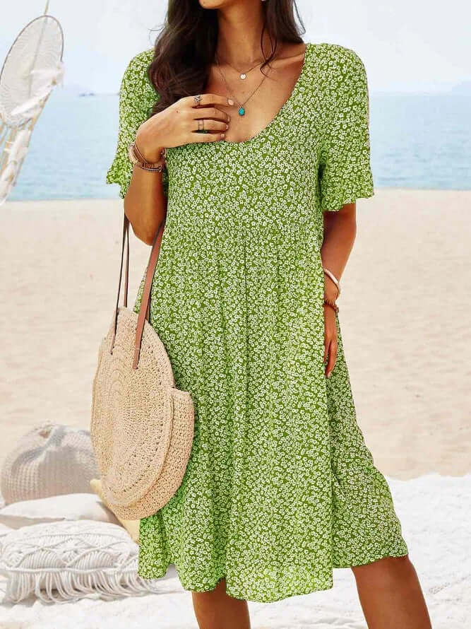 Stylish women's flowy midi dress with vibrant floral print, v-neck, short sleeves, great for spring-summer fashion.