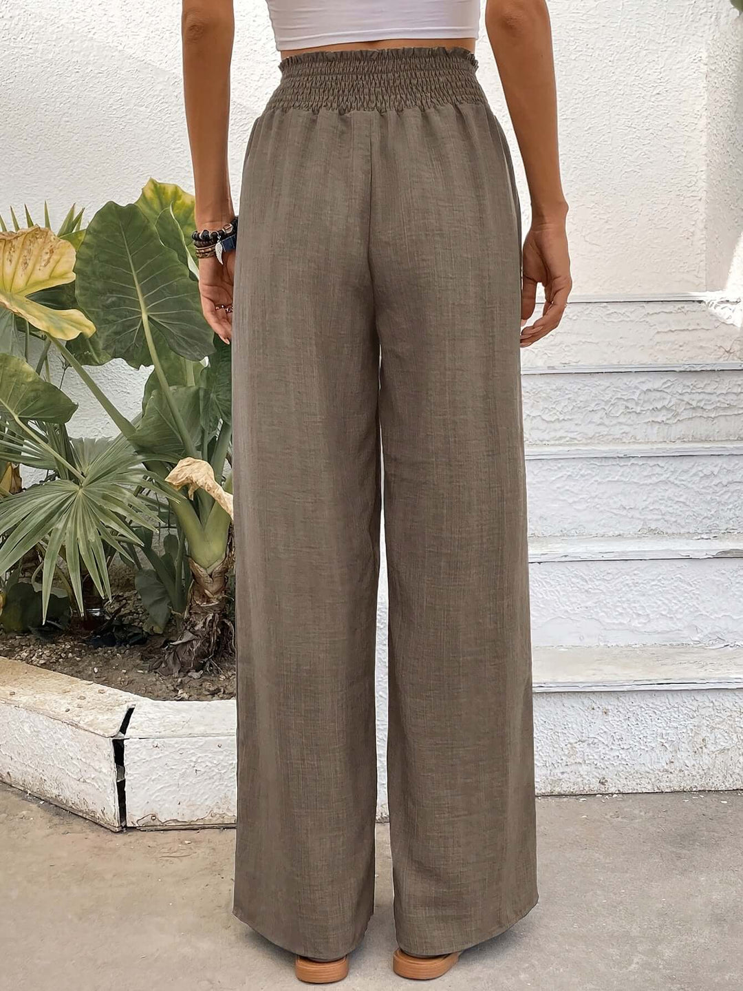 Effortless brown flowy high-waisted wide-leg pants. Comfortable loose fit for chic casual spring style.