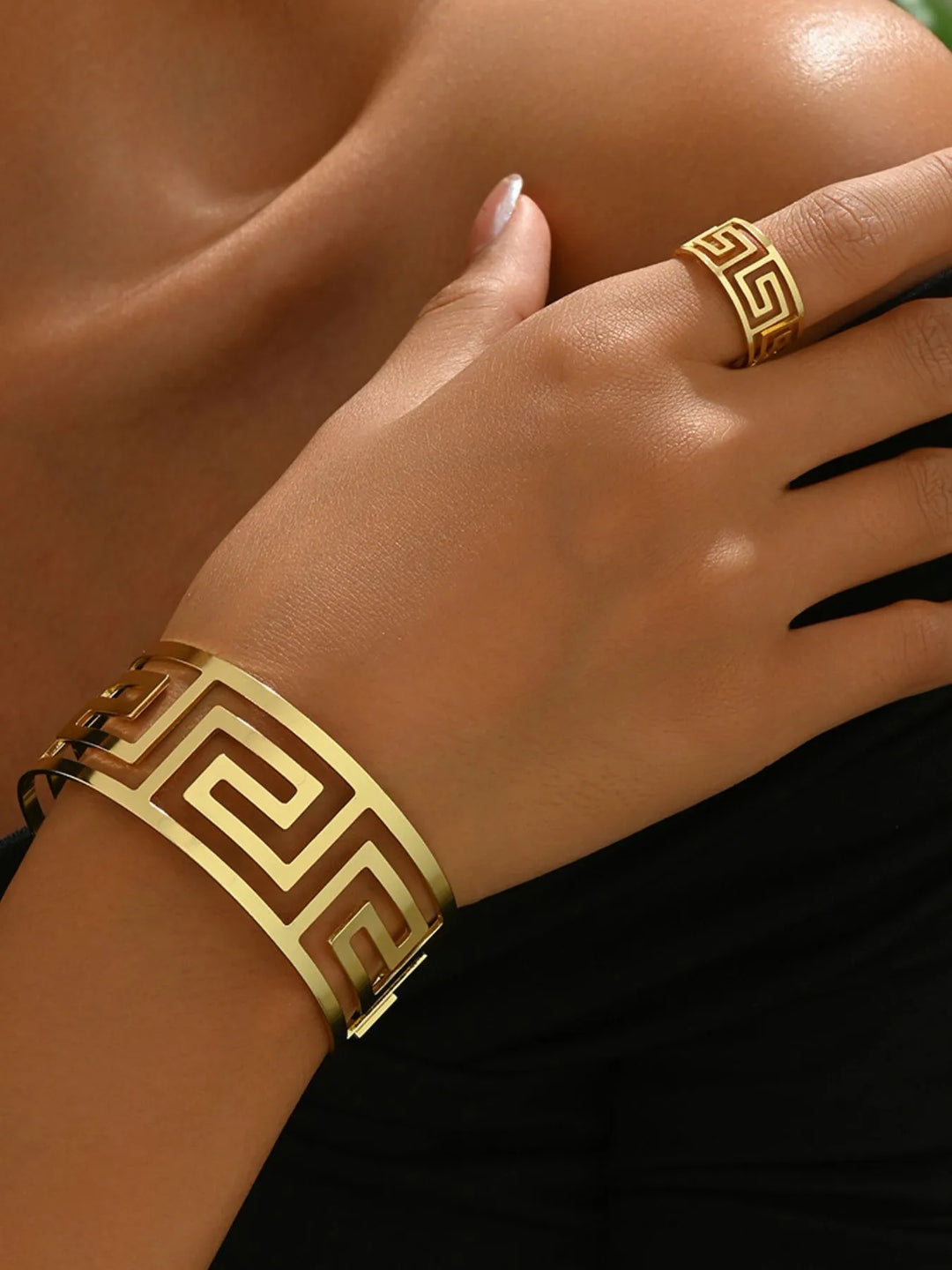 Fashionable women's geometric gold tone cuff bracelet & matching ring set. Versatile jewelry accessory.