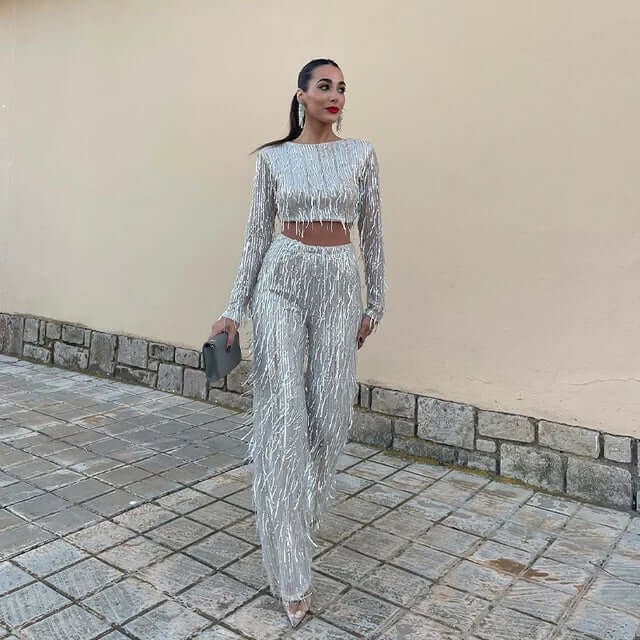 Sparkly women's sequin crop top with long sleeves & high-waisted trousers, ideal party wear.