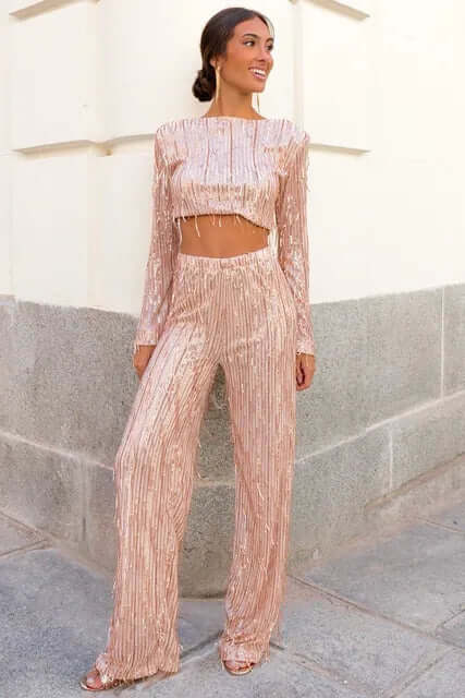 Women's two-piece sequin outfit: crop top & high-waisted trousers for a glamorous evening look.