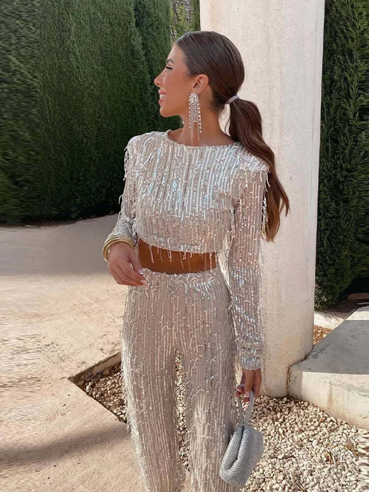 Shiny women's sequin crop top & high-waisted trousers set, a stylish two-piece party outfit.