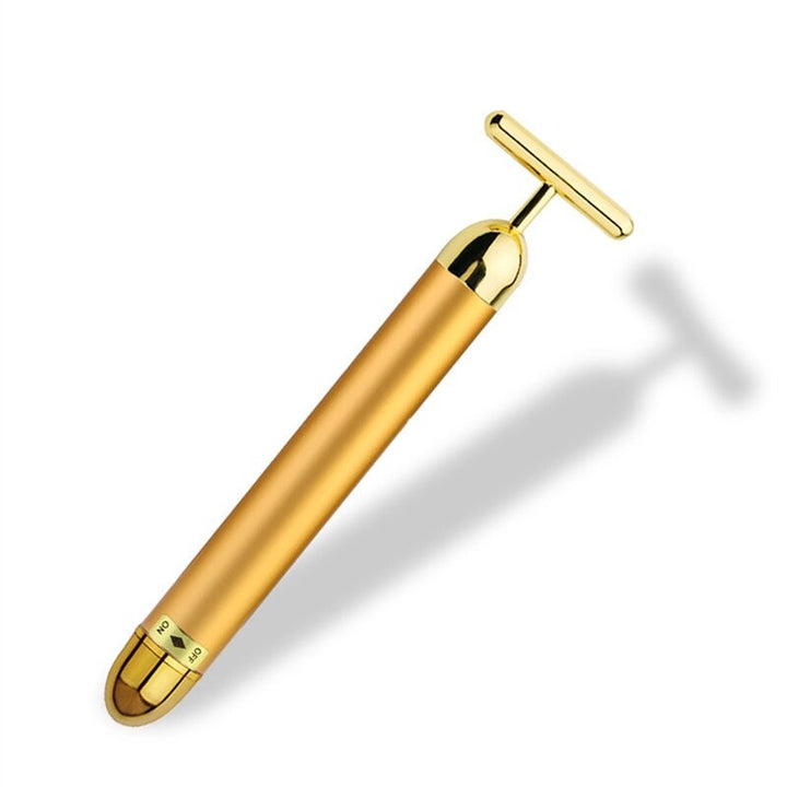 Women's gold vibrating facial roller for radiant skin, promoting anti-aging and enhancing skincare absorption.