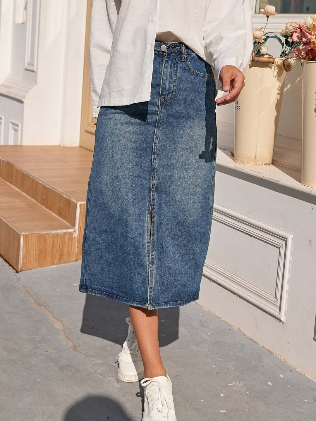 Modern blue denim midi skirt for women, high-waisted with a stylish front slit, perfect for spring/summer.