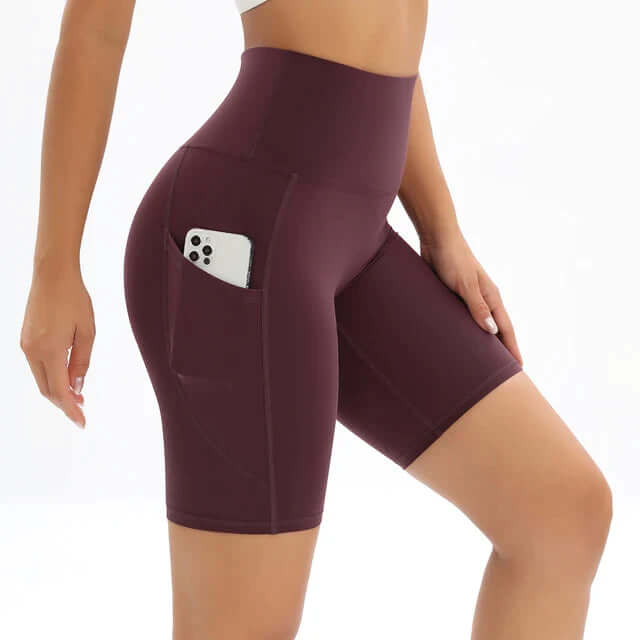 Women's high-waisted fitness shorts in black with a convenient phone pocket, perfect for workouts & gym.