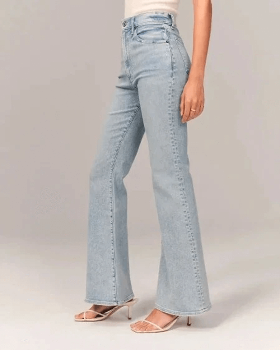 Fashionable women's flared high-waisted denim jeans in classic blue, emphasizing a flattering retro fit.