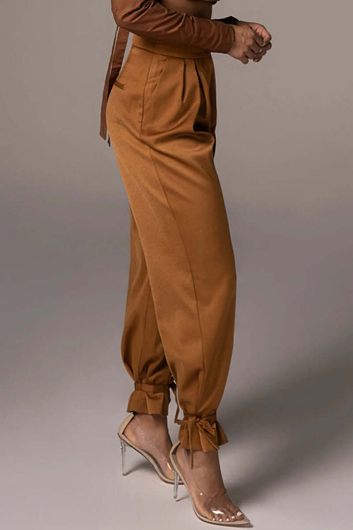Pleated high-waisted tapered trousers for women with stylish ankle ties, offering a comfortable fit.