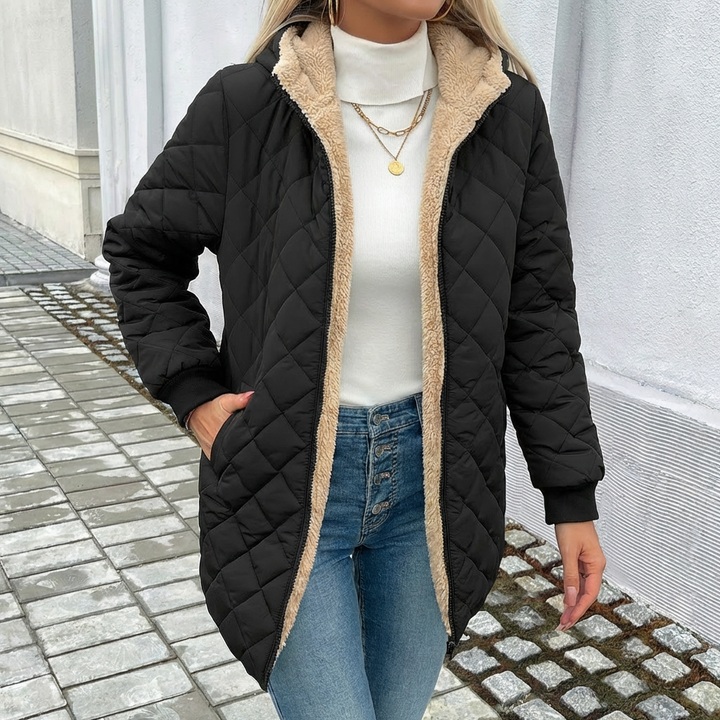 Stylish women's black quilted puffer jacket with a hood. Ideal warm longline outerwear for winter fashion.