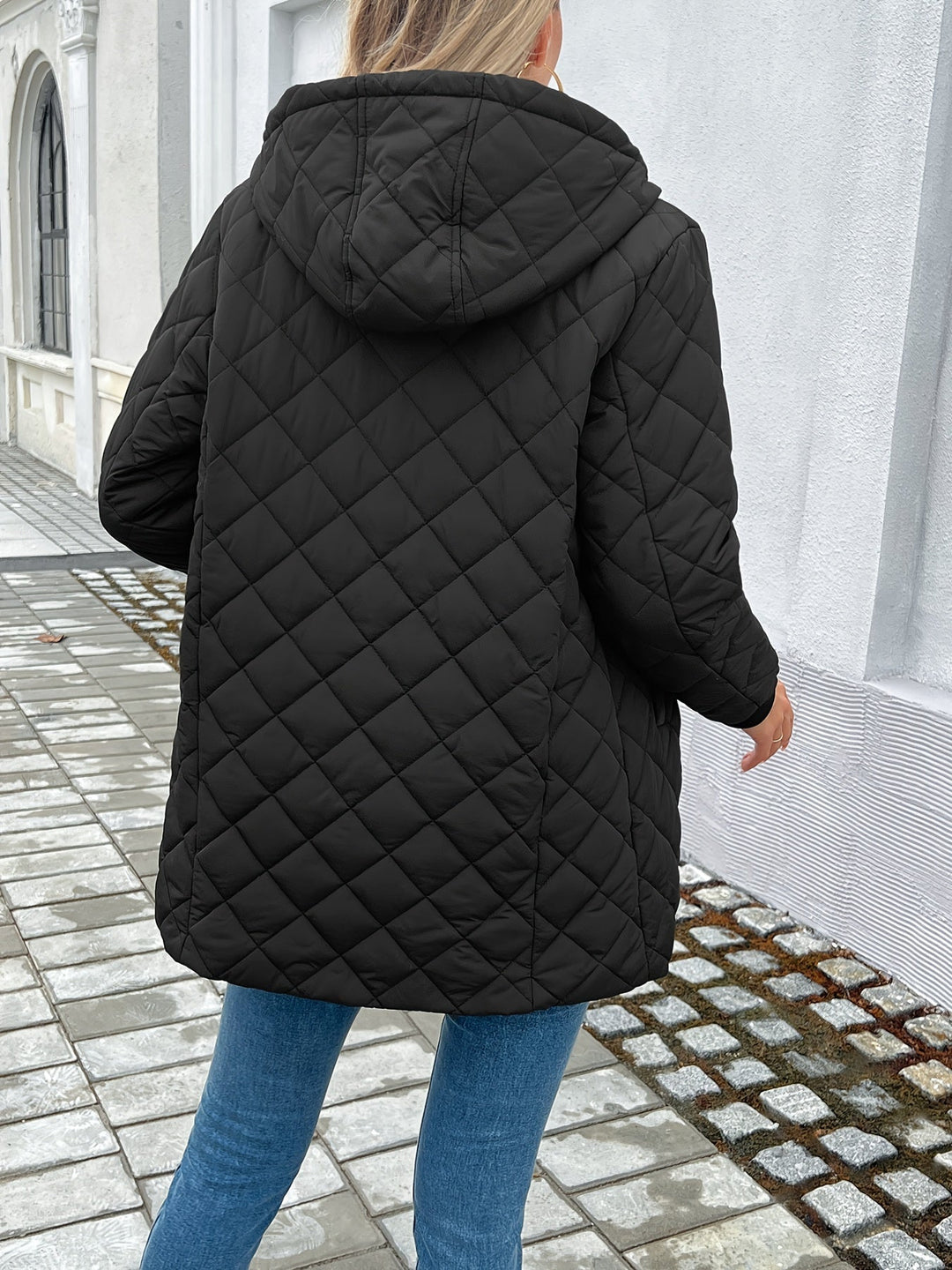 Women's warm black hooded longline quilted coat, a stylish and cozy puffer jacket for fall and winter.
