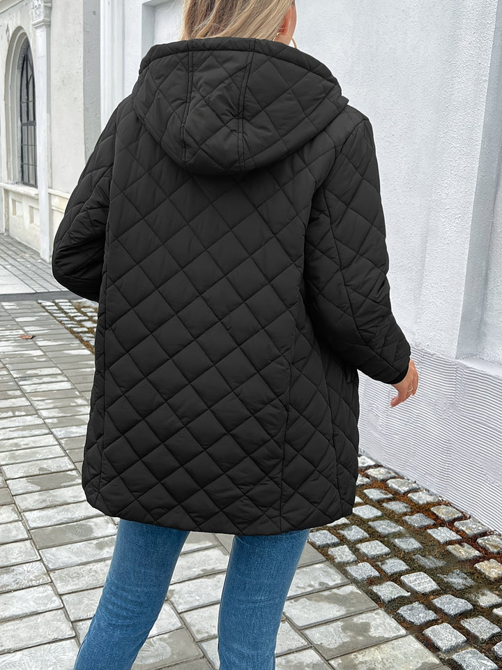Women's warm black hooded longline quilted coat, a stylish and cozy puffer jacket for fall and winter.