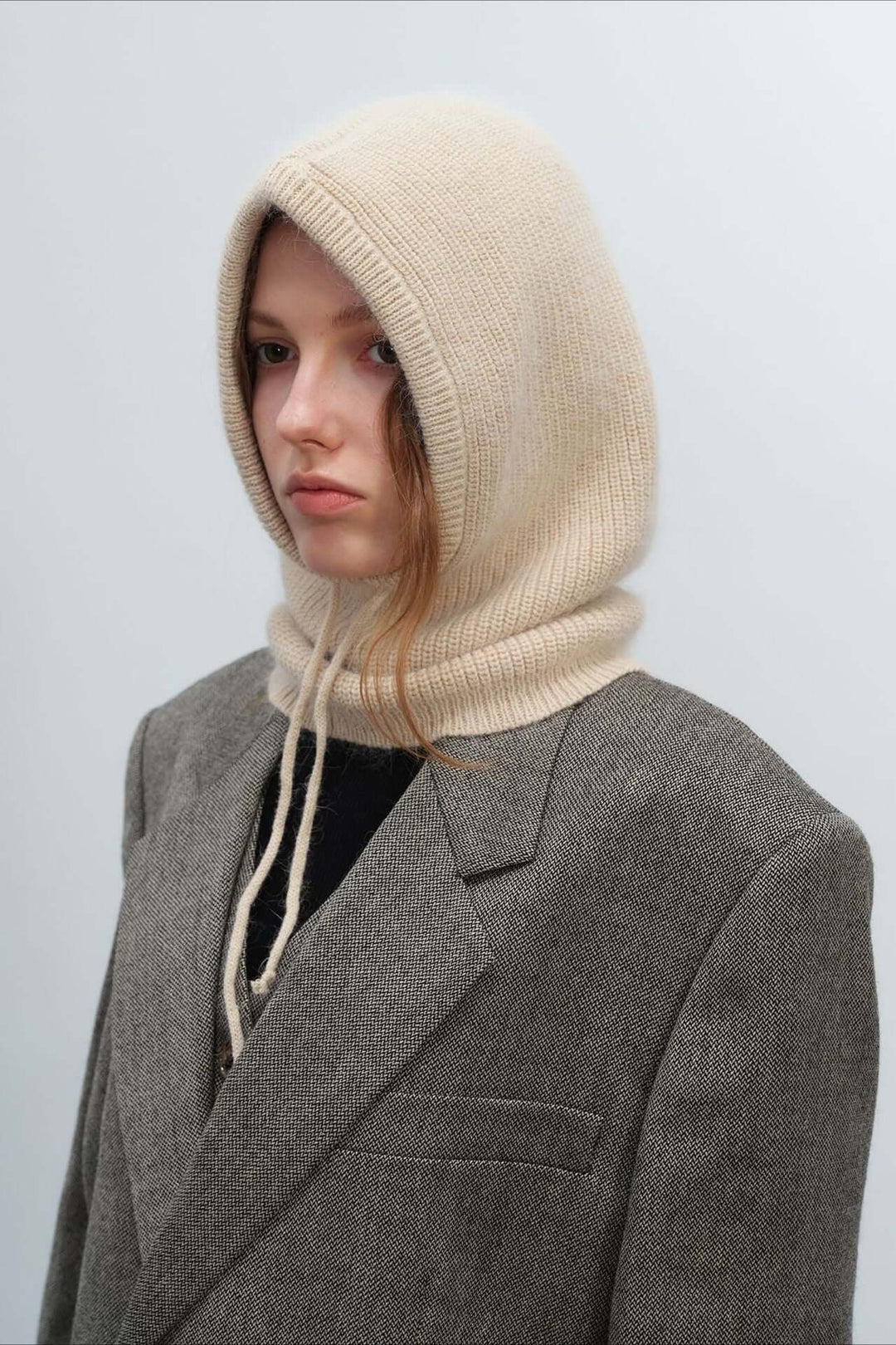 Cozy knitted balaclava hood for women, providing warm winter protection & stylish headwear comfort.