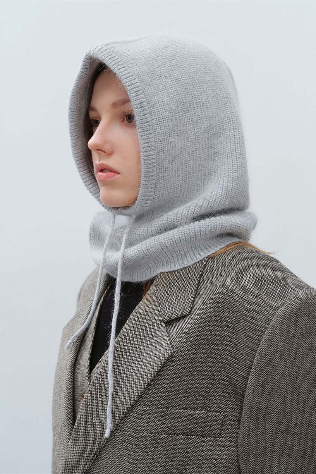 Woman wearing a cozy knitted balaclava hood, perfect warm winter scarf for cold weather activities.
