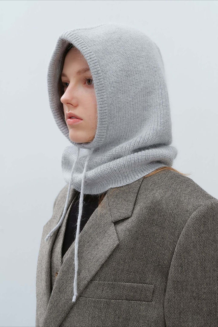 Woman wearing a cozy knitted balaclava hood, perfect warm winter scarf for cold weather activities.