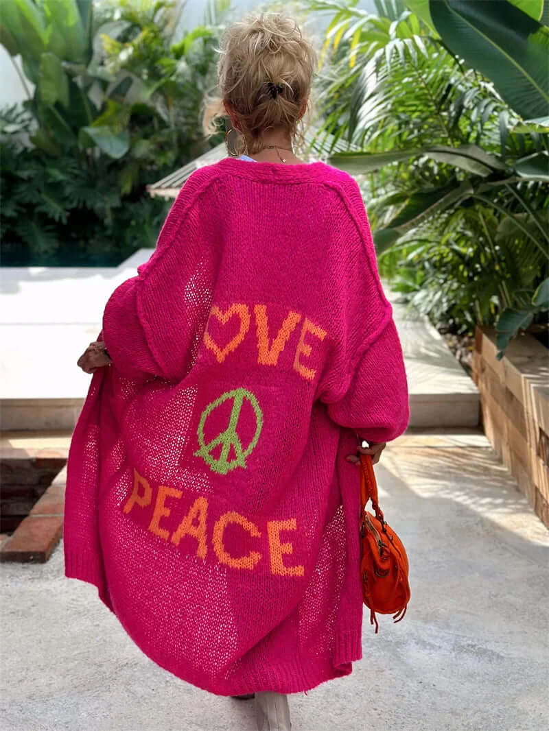 Women's knitted cardigan featuring "Love Peace" design. Warm, comfortable sweater for fall & winter layering.