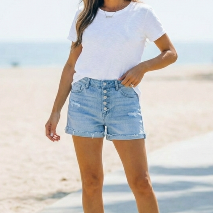 Stylish women's button fly jorts in light blue denim. Comfortable mid-thigh shorts, ideal for casual summer wear.