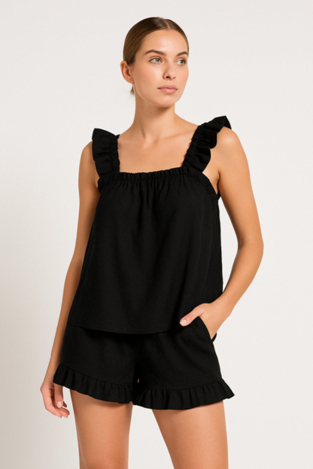 Feminine two-piece women's ruffle pajama set. Lightweight sleeveless top & matching shorts, ideal summer sleepwear.