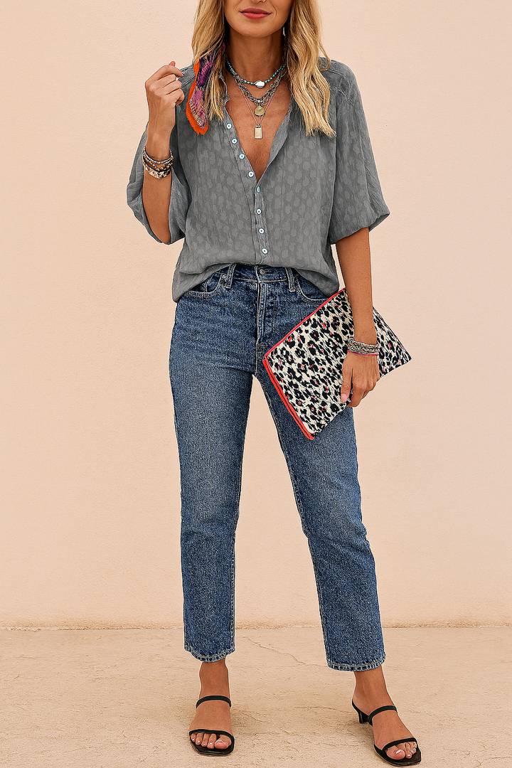 Elegant yet casual women's button-up summer blouse, offering a trendy loose fit for warm weather.