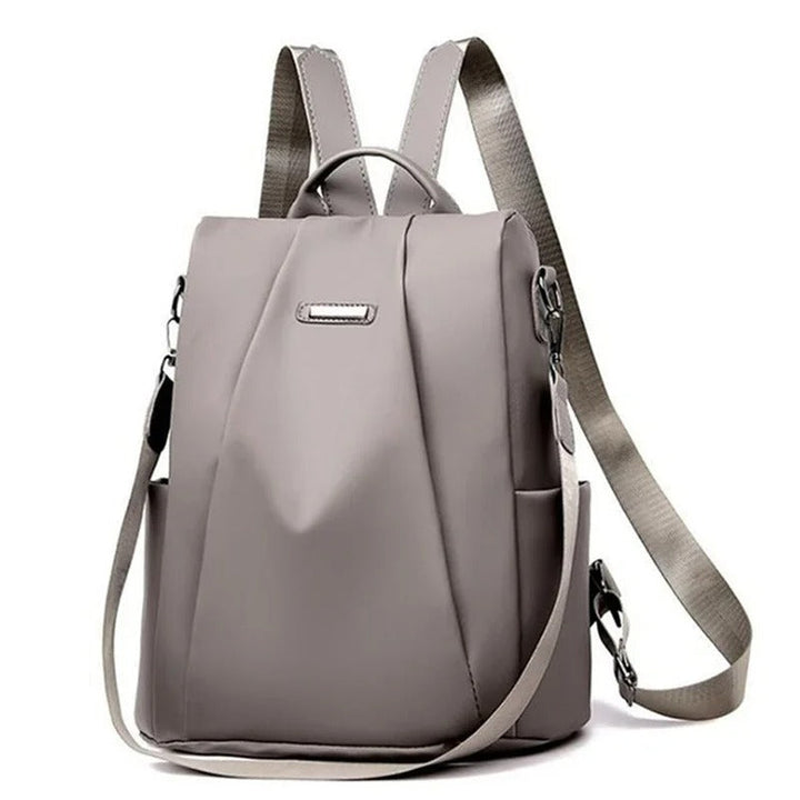 Fashionable woman wearing a lightweight water-resistant nylon backpack. Multi-way carry for everyday style.