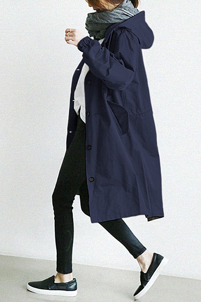 Woman wearing a versatile lightweight hooded rain trench coat, great for travel & outdoor activities.