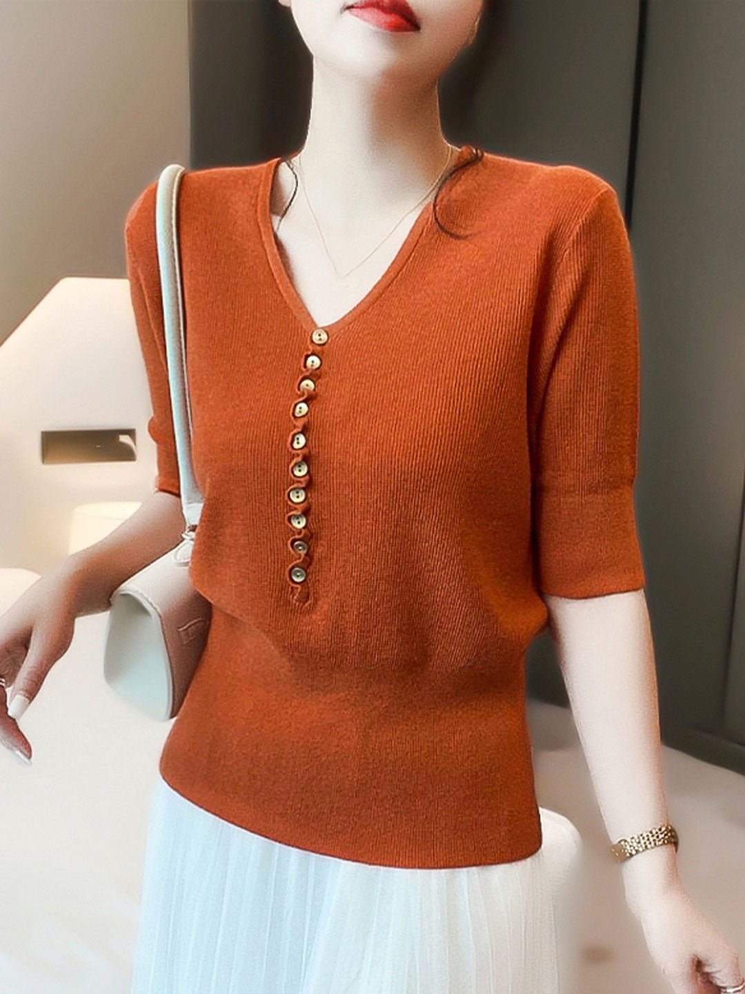 Breathable relaxed fit women's knitted sweater, V-neck and button details for comfort.