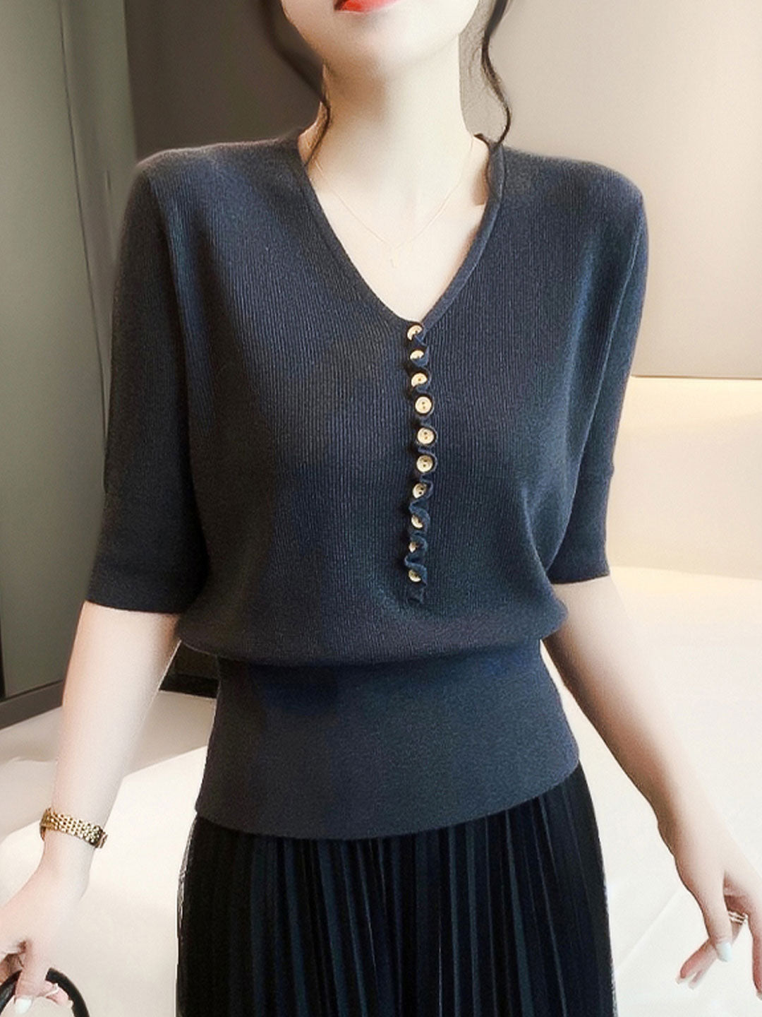Detailed view of a women's V-neck button knitted top, highlighting soft knit fabric.