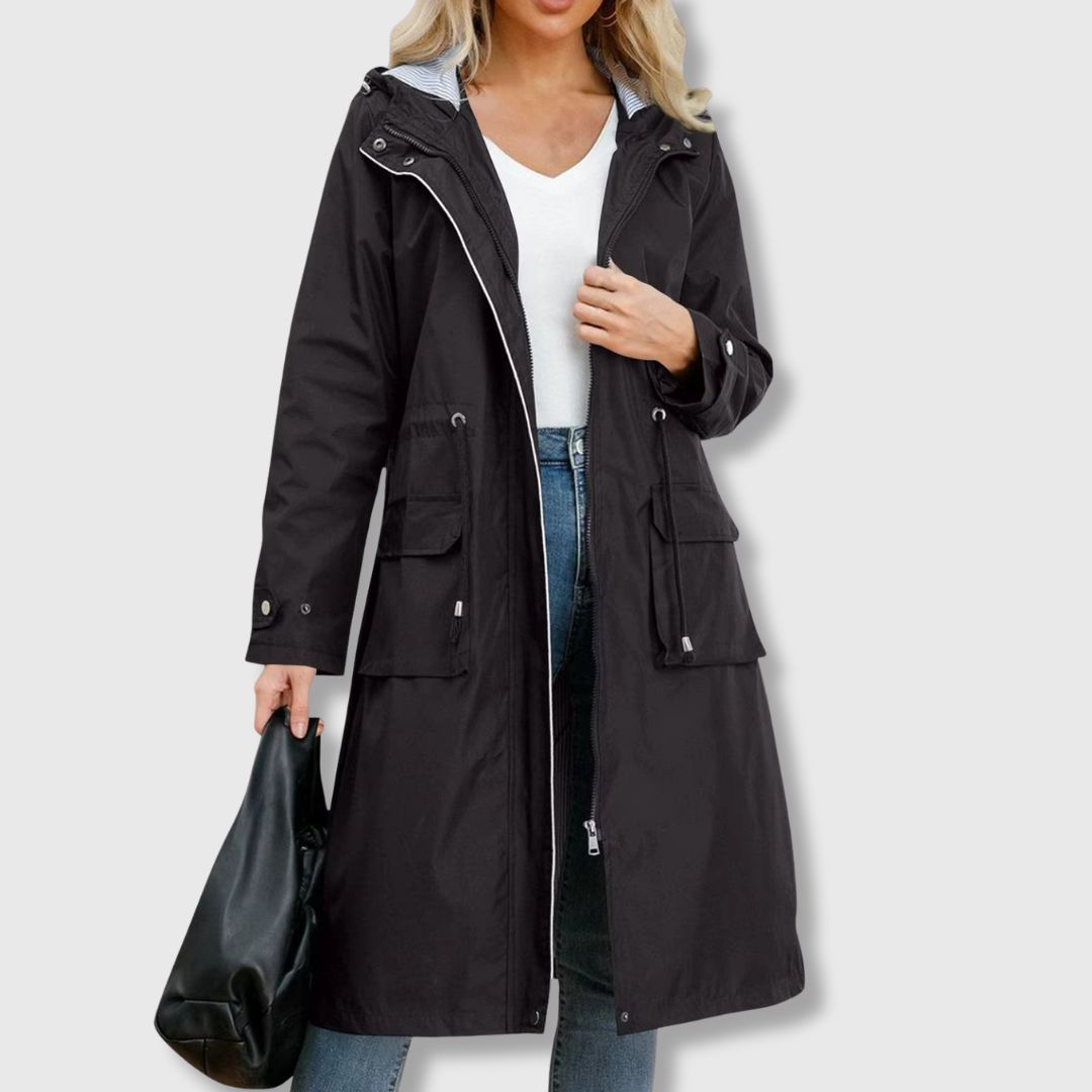 Elegant women's long rain jacket with hood, waterproof fabric, & an adjustable drawstring waist. Practical everyday style.