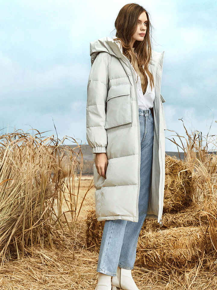Insulated women's long puffer coat with a hood, ideal warm outerwear for everyday winter use.