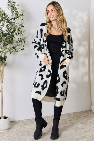 Soft knitted women's longline cardigan featuring a chic leopard print. Perfect cozy outerwear.