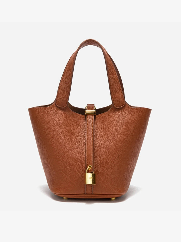 Detail of the minimalist hardware on the chic women's leather bucket bag, modern accessory.