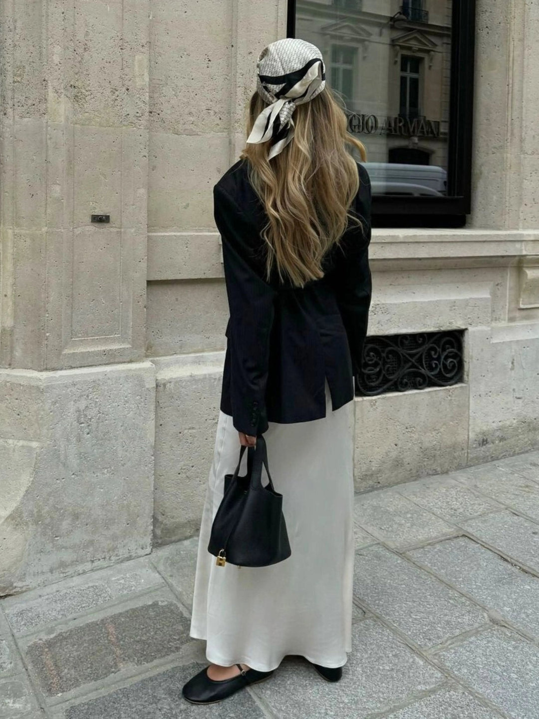 Women's modern leather bucket bag complementing a chic casual outfit for everyday sophistication.