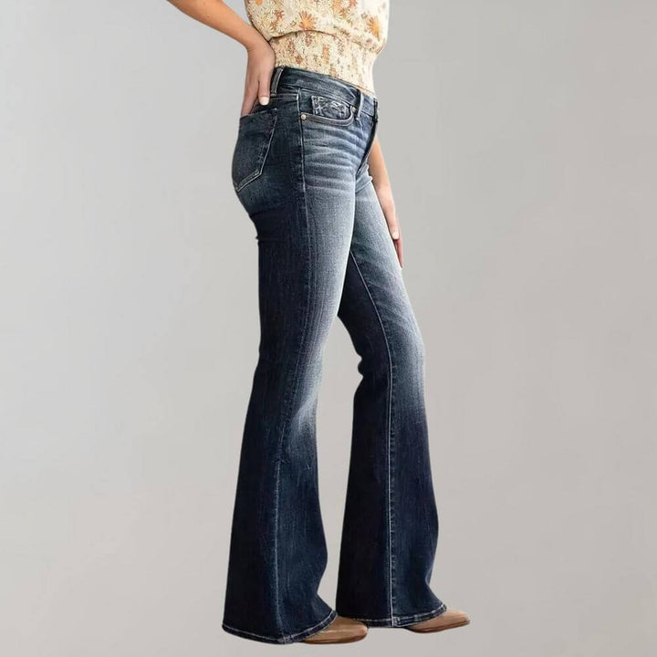 Trendy women's mid-waist slim fit stretch flared blue jeans. Perfect retro denim apparel.