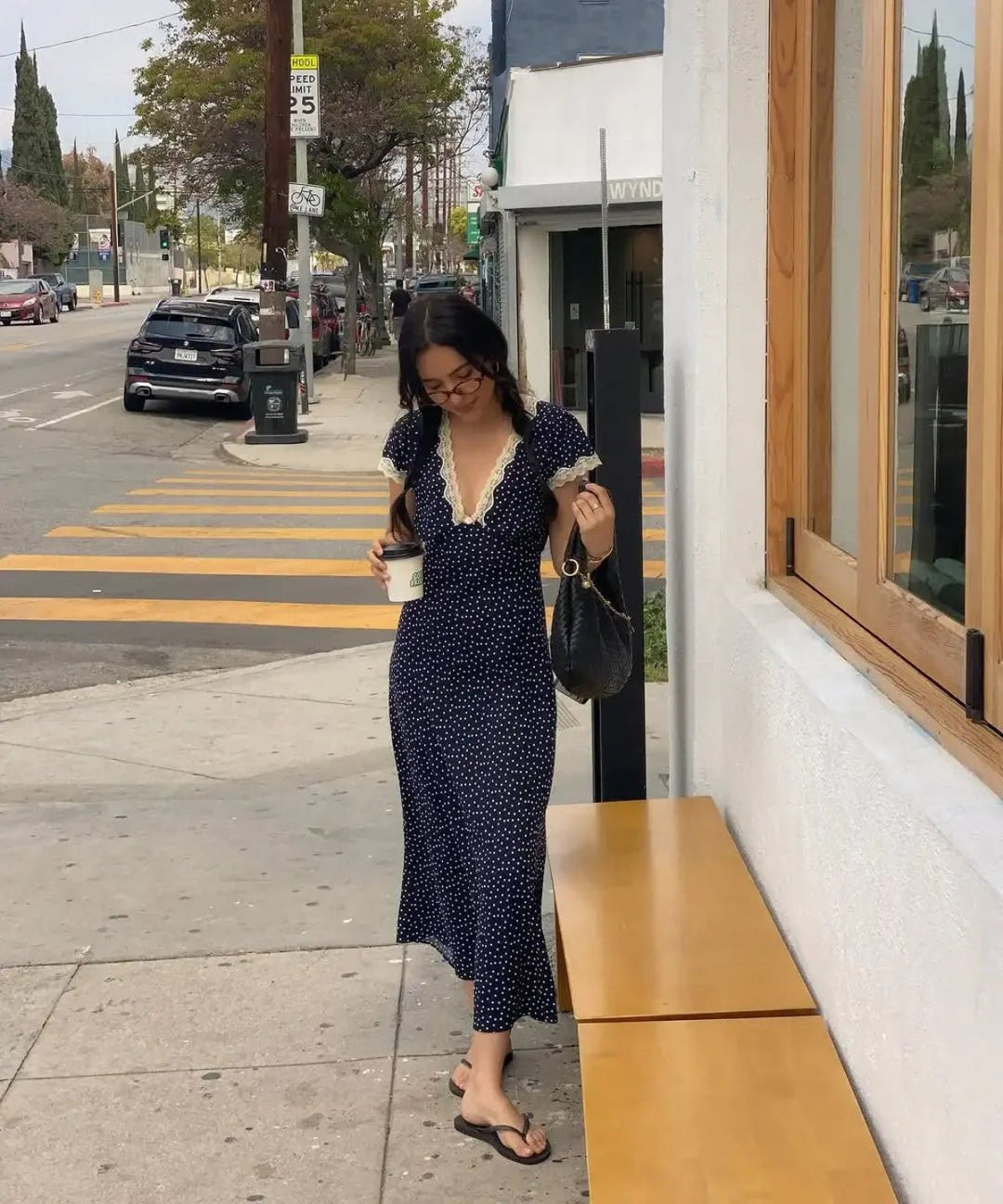 Women's navy polka dot midi summer dress with flutter sleeves. Lightweight and elegant for casual day wear.