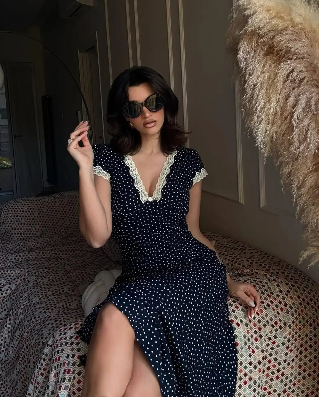 Lightweight navy polka dot midi dress for women. Features flutter sleeves, ideal for casual or elegant summer fashion.