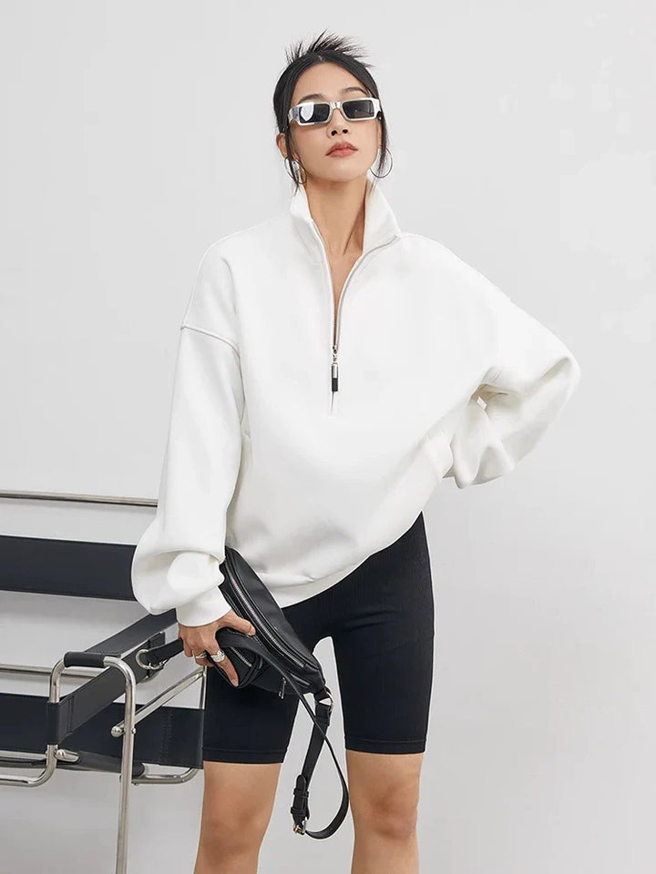 Woman wearing an oversized half-zip pullover hoodie, ideal for cozy casual wear & relaxed winter fashion.