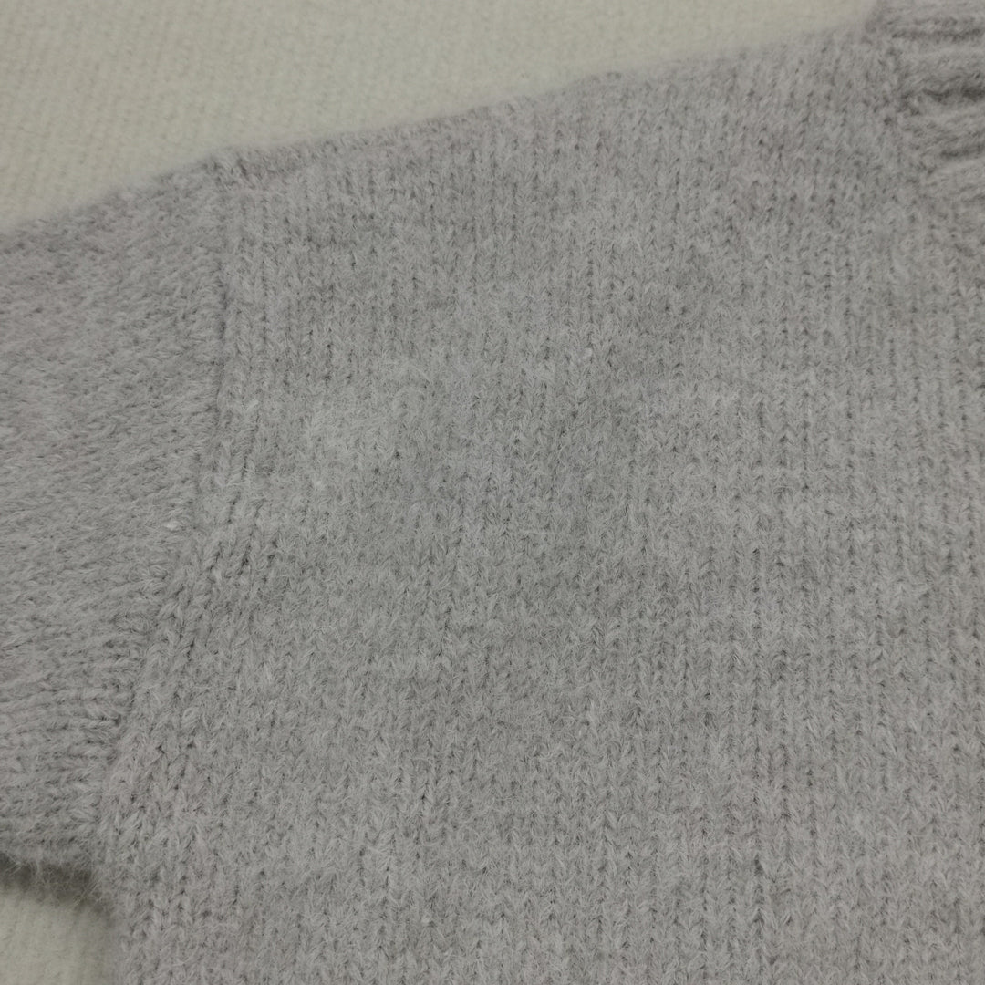 Women's oversized knitted jumper, versatile cream knit for everyday cozy wear.