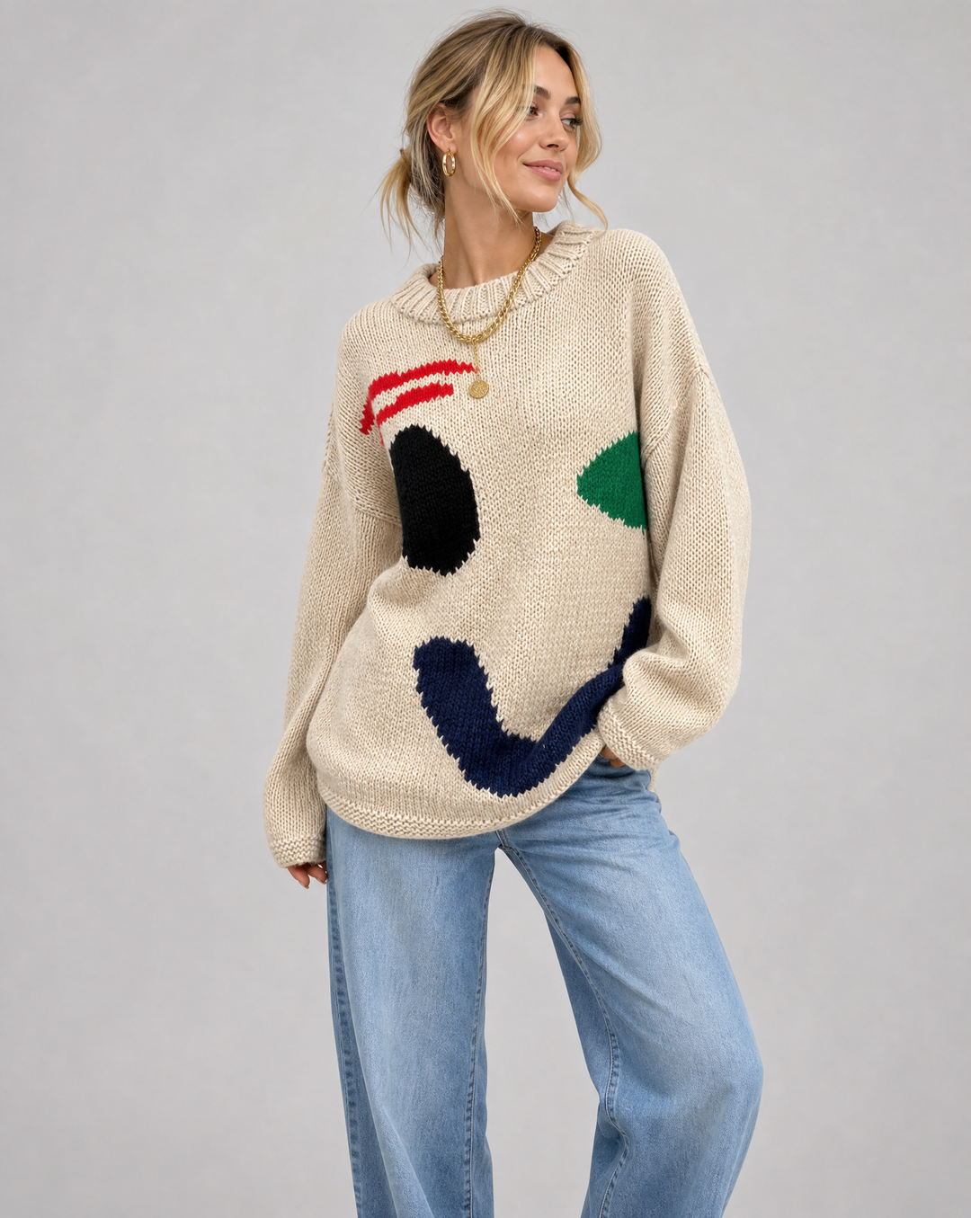 Women's oversized smiley face sweater, cozy knit pullover for autumn fashion.