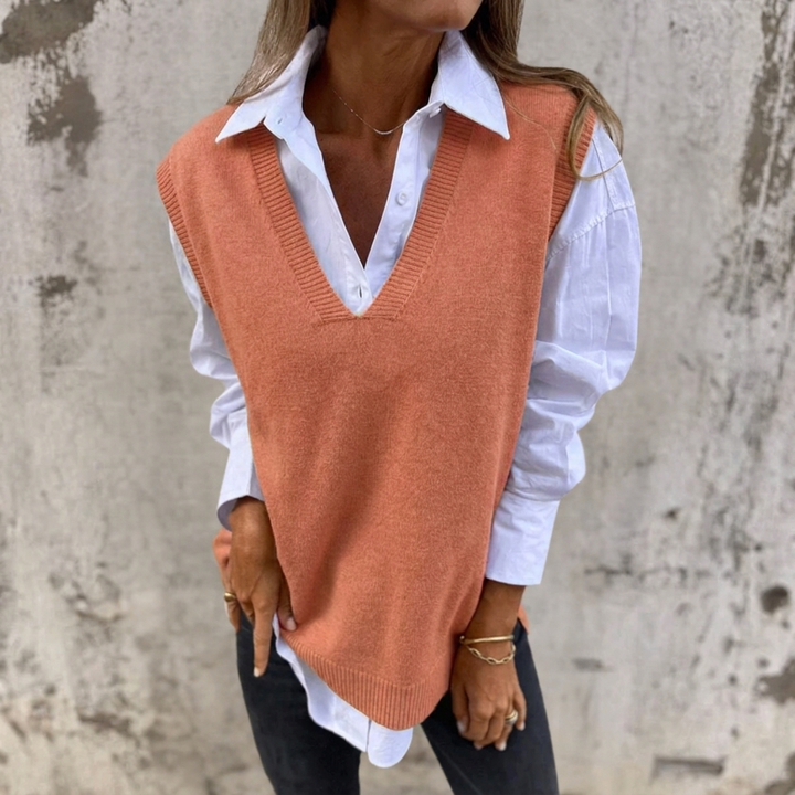 Women's oversized V-neck knitted vest in cream, styled over a shirt for chic layering.