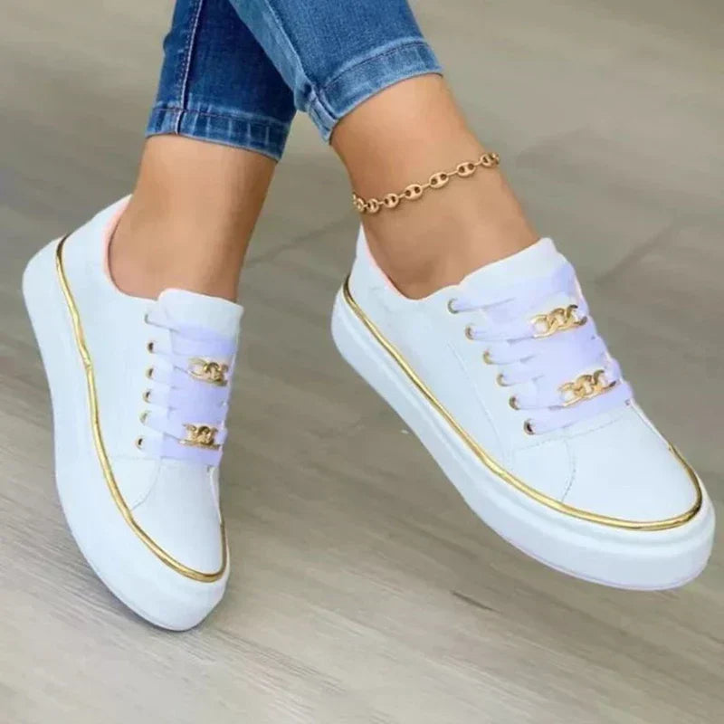 Trendy women's footwear: platform sneakers with eye-catching gold chain and comfortable low-top style.