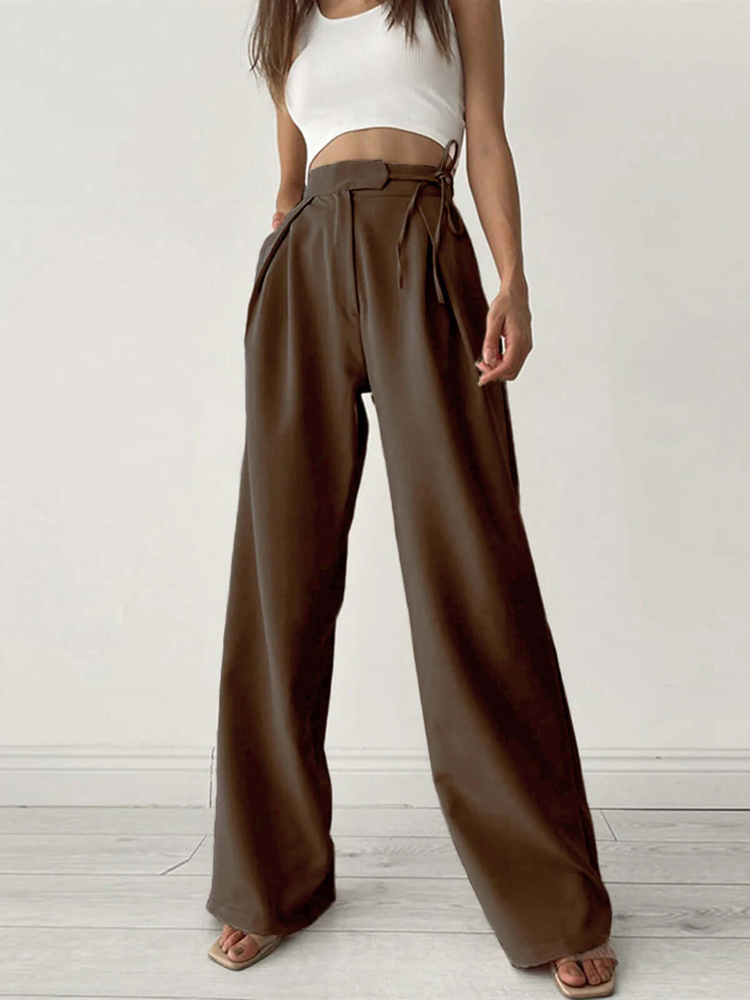 Lightweight beige pleated palazzo trousers, women's high-waist wide-leg for breezy summer fashion.