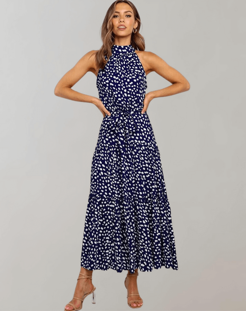 Full-length shot of a women's polka dot halter maxi dress, elegant & flowy.