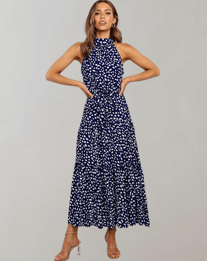 Full-length shot of a women's polka dot halter maxi dress, elegant & flowy.