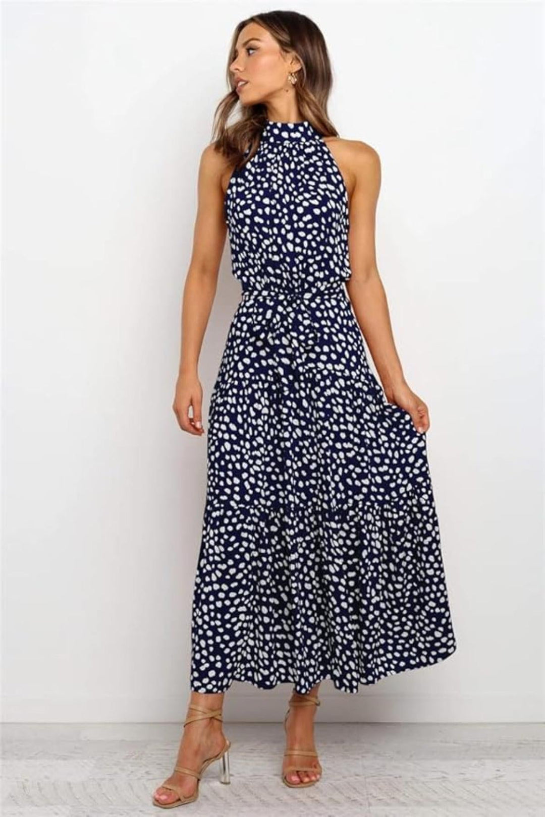 Navy blue polka dot halter midi dress with a flowy skirt, perfect for summer.