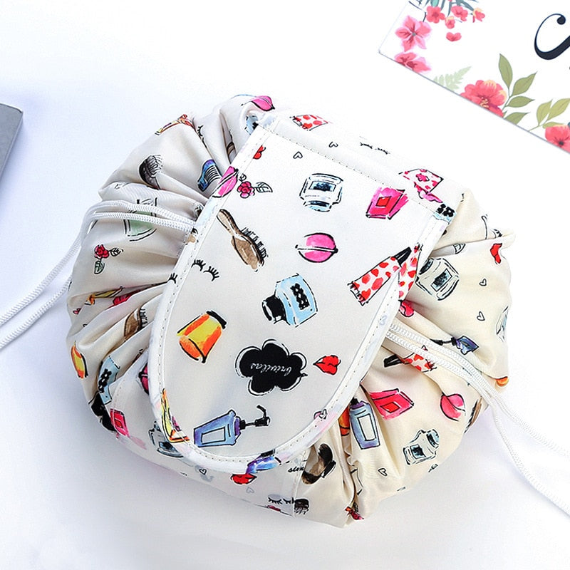 Woman's hand tightening a pink portable drawstring cosmetic travel bag.