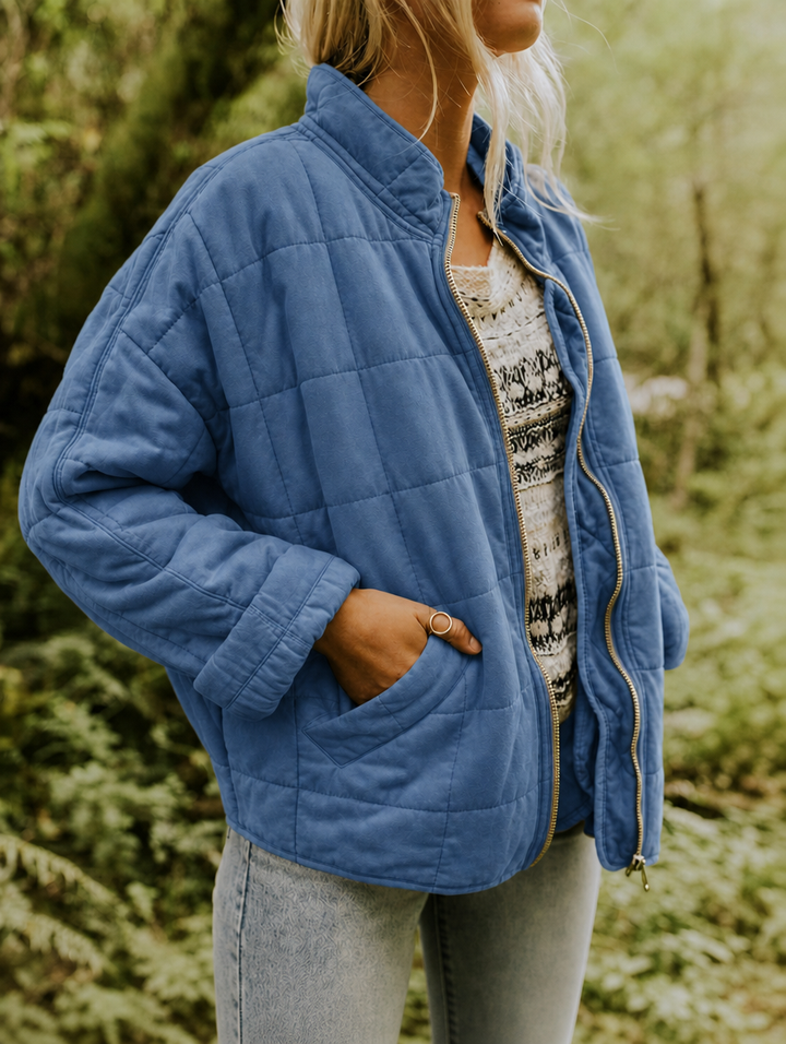 Side view of a women's zip-front quilted jacket, showcasing a sleek silhouette & practical pockets.