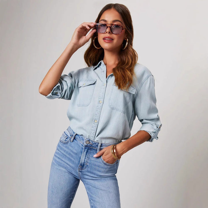 Blue denim women's shirt, relaxed fit, long sleeve, button-down with chest pockets. Perfect casual fashion top.