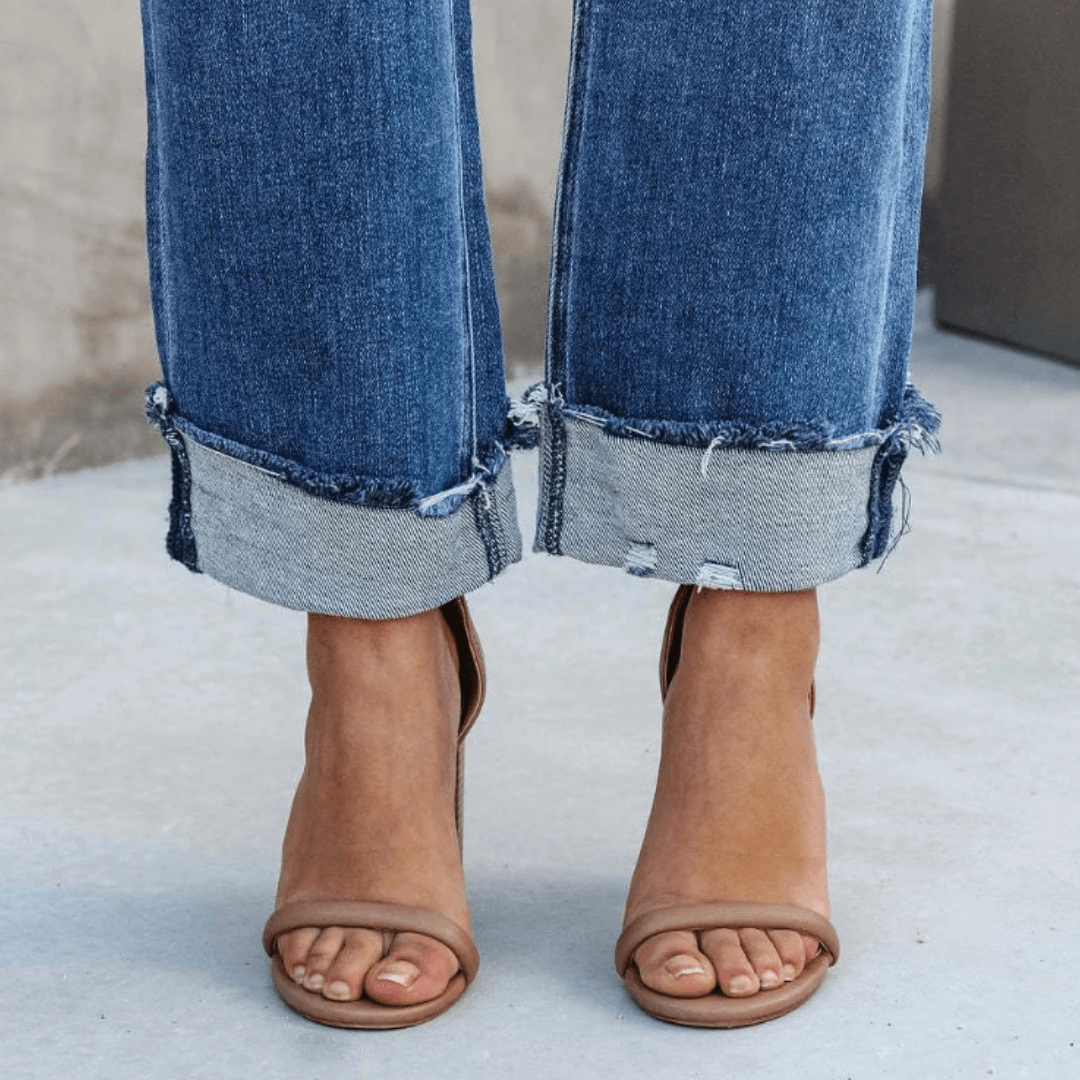 Stylish women's blue denim jeans, relaxed fit, showcasing a fashionable irregular waist. Great for casual wear.