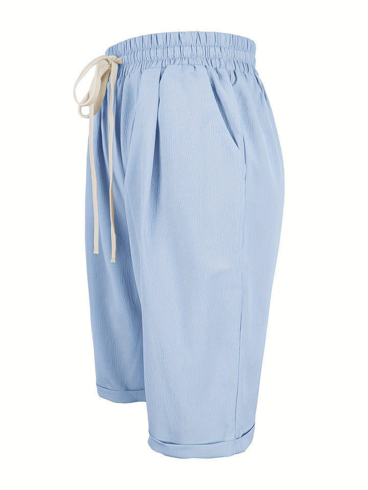 Close-up of comfortable women's relaxed fit capri pants, showcasing elastic waistband & pockets.